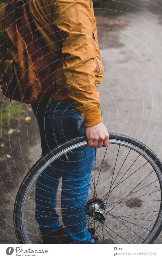 Ein Mann hält einen Fahrradreifen Mensch maskulin Junger Mann Jugendliche Erwachsene 1 18-30 Jahre Umweltschutz Rad Reifen Herbst Wege & Pfade Radrennen
