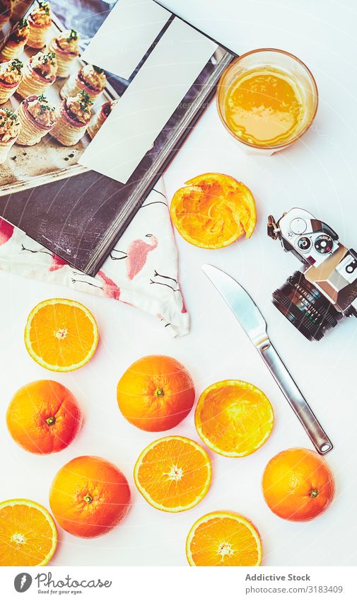 Anordnung von Orangen und Fotokamera Zusammensetzung kochen & garen Buch Fotoapparat altehrwürdig Entwurf Saft Küche frisch Zutaten drücken Lebensmittel