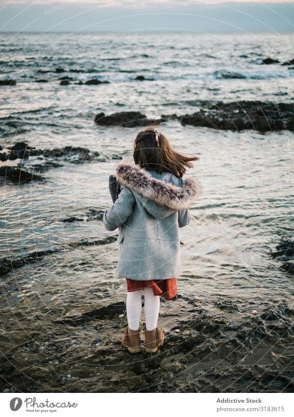 Rückansicht des kleinen Mädchens mit Blick auf das Meer Strand Aussicht Freiheit Rücken reizvoll Winter stehen Kind Sand Wasser Ferien & Urlaub & Reisen weiß