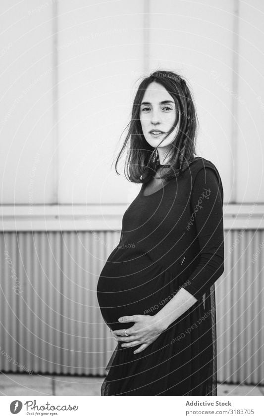Schwangere Frau, die auf der Stadtstraße steht. schwanger Straße Großstadt Straßenbelag berühren bauchfrei Erwachsene Mutterschaft genießen Lifestyle erwartend