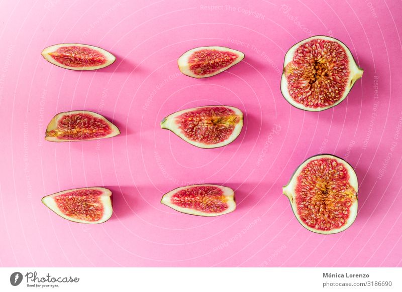 Reife Feigen auf rosa Hintergrund geschnitten. Minimale flache Verlegung. Frucht Ernährung Diät exotisch Herbst frisch rot roh Hälfte Jahreszeiten süß Scheibe