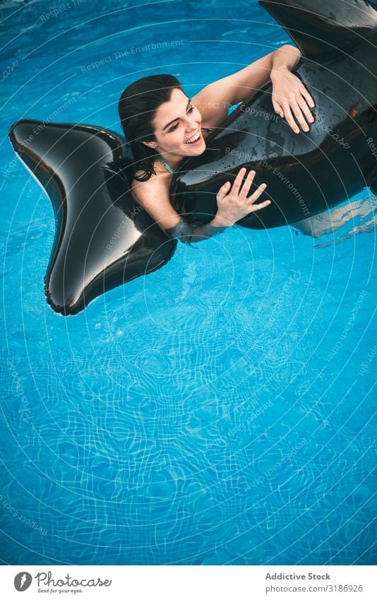 Mädchen mit aufblasbarem Spielzeug, das im Wasser posiert. Körperhaltung Schwimmbad Freude Reiten Fisch Ausritt Schwimmsport Glück Lächeln hübsch