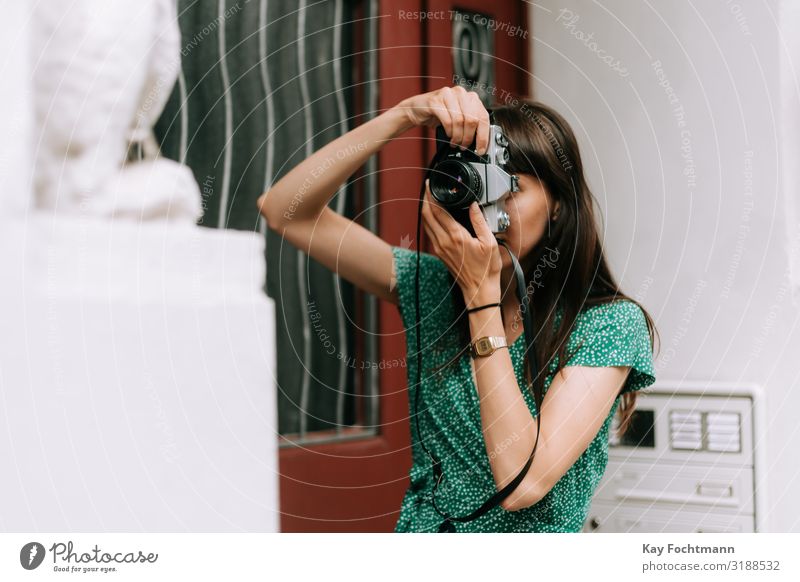elegante Frau in grünem Kleid macht ein Foto mit einer alten Filmkamera Aktivität analog Schönheit Fotokamera erfassend Kaukasier entdeckend Eleganz Europäer
