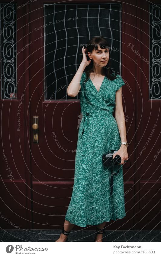 elegante Frau in grünem Kleid hält eine alte Filmkamera in den Händen Aktivität analog Schönheit Fotokamera erfassend Kaukasier entdeckend Eleganz Europäer