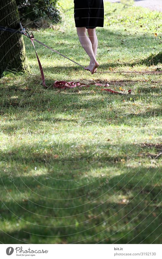 Zwei Beine barfuß beim Seillaufen auf einem Seil, festgebunden am Baum, draussen in der Natur im Garten oder Park. Freizeit & Hobby Sport Fitness Sport-Training