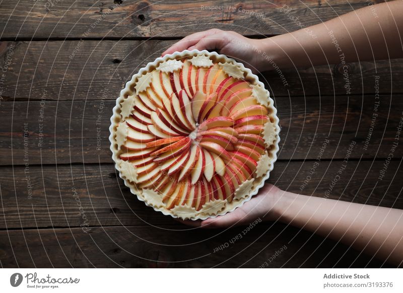 unkenntliche Frau, die einen leckeren Apfelkuchen auf einem Holztisch zeigt. Pasteten frisch rustikal Fenster gebastelt Tag braun Konfekt organisch Pergament