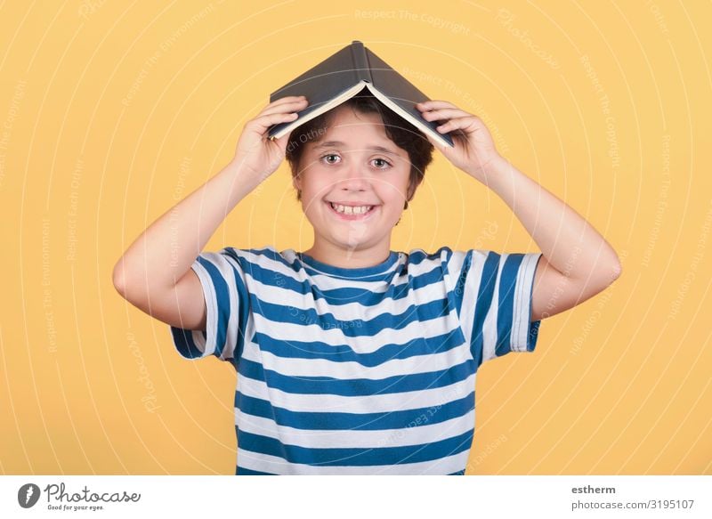glückliches Kind mit Buch auf dem Kopf Lifestyle Freude Spielen lesen Schule lernen Schulkind Mensch maskulin Kindheit 1 8-13 Jahre Lächeln lachen Fröhlichkeit