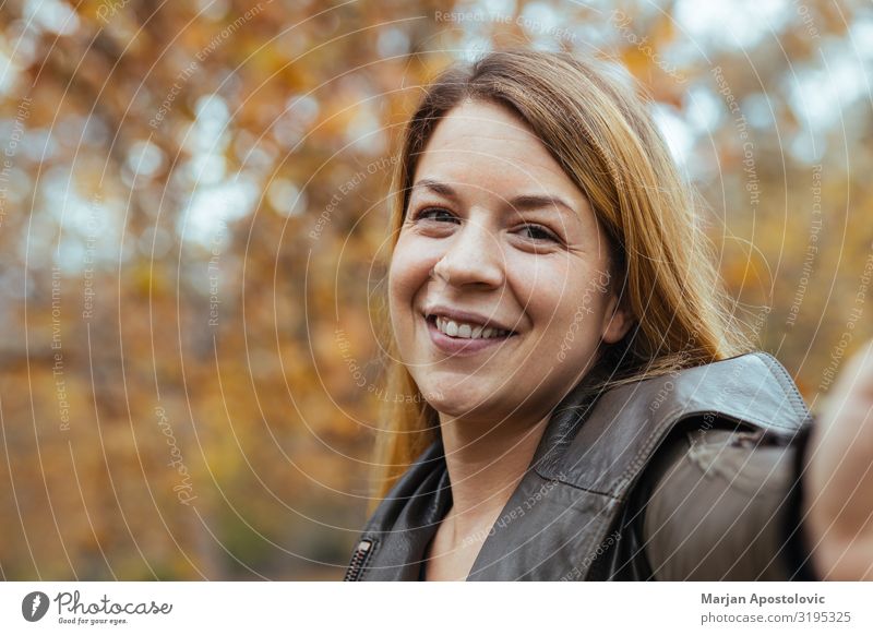 Junge Frau, die im Herbst ein Selfie im Park macht Funktelefon Fotokamera Mensch feminin Jugendliche Erwachsene Gesicht 1 30-45 Jahre blond langhaarig Lächeln