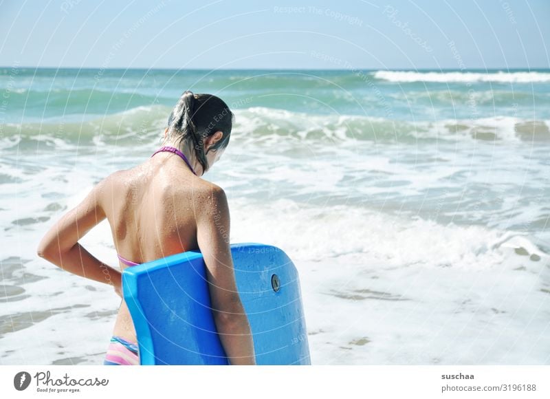 mädchen im bikini von hinten vor dem unruhigen meer stehend mit einem surfbrett unter dem arm Kind Mädchen Bikini Urlaub Ferien Sommer Wasser Meer Strand