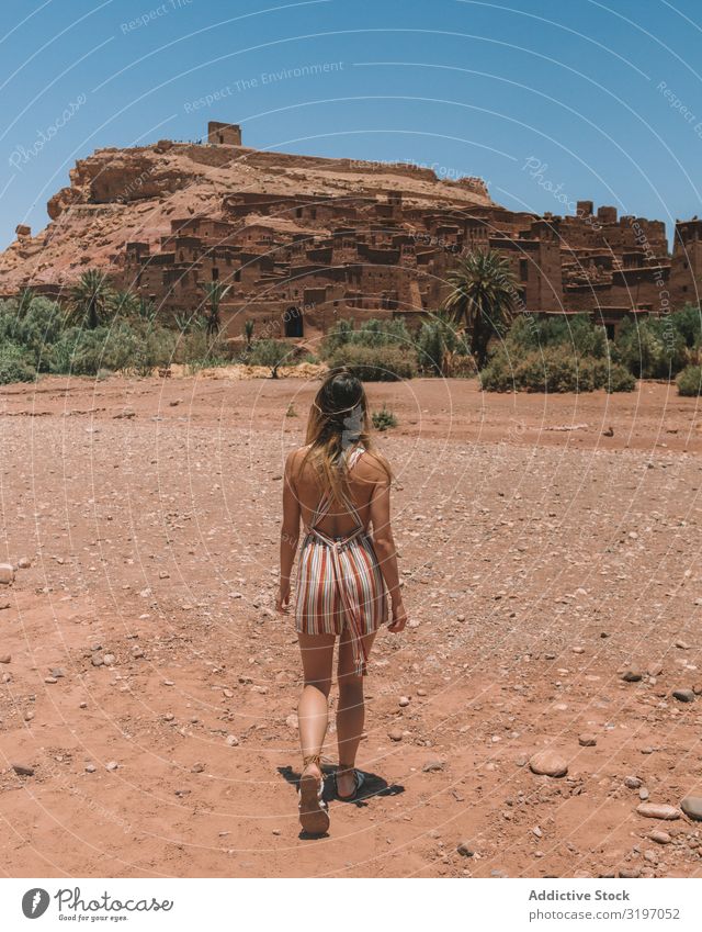 Frau, die in der Wüste spazieren geht, mit einer alten Stadt. Großstadt Marokko Felsen antik laufen erkunden Ferien & Urlaub & Reisen Tourismus Sommer