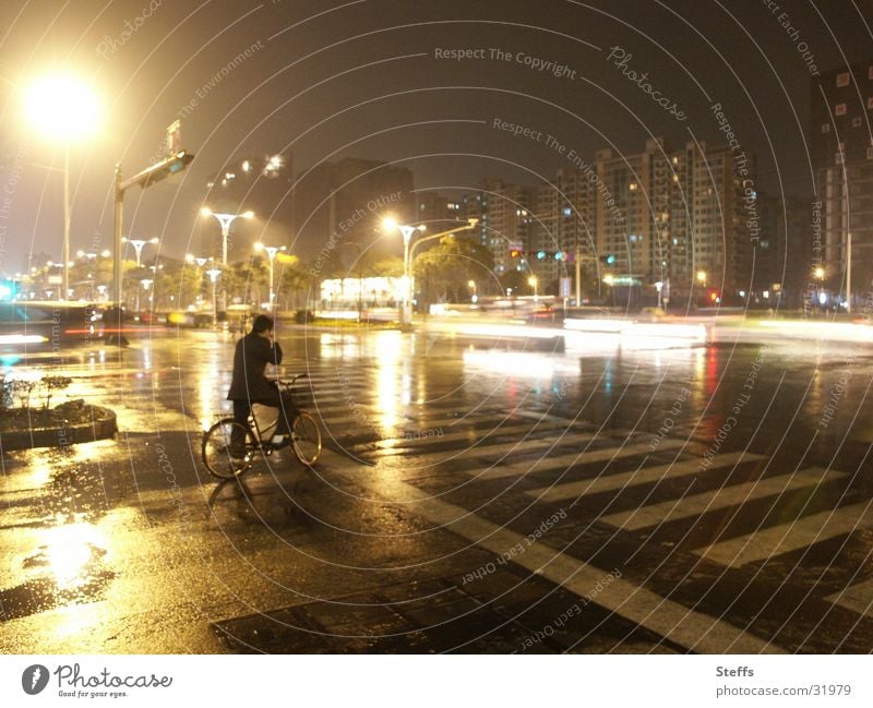 chinesische Strasse im Regen China Fahrrad Nacht Licht Verkehr Chinesisch Reflexion & Spiegelung Zebrastreifen gelb grau Mann Straßenkreuzung Einsamkeit dunkel