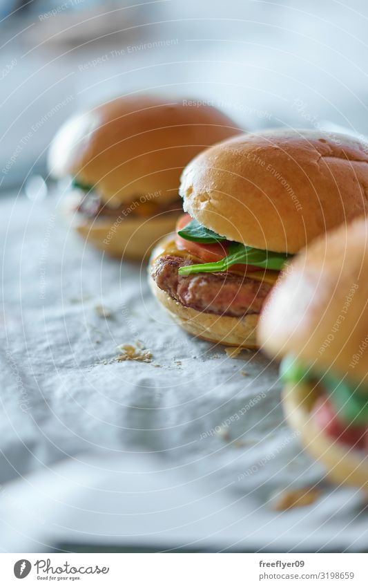 Hausgemachte Hamburger auf Backpapier Fleisch Käse Gemüse Brot Brötchen Ernährung Mittagessen Fastfood Gastronomie Papier Zettel frisch lecker natürlich
