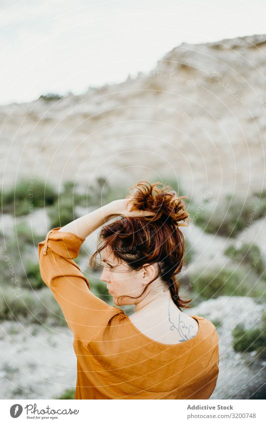 Verträumte attraktive junge Frau, die im Freien posiert träumen Körperhaltung Jugendliche Model Porträt Fürsorge Bluse Hand wild Wüste Landschaft brünett Natur