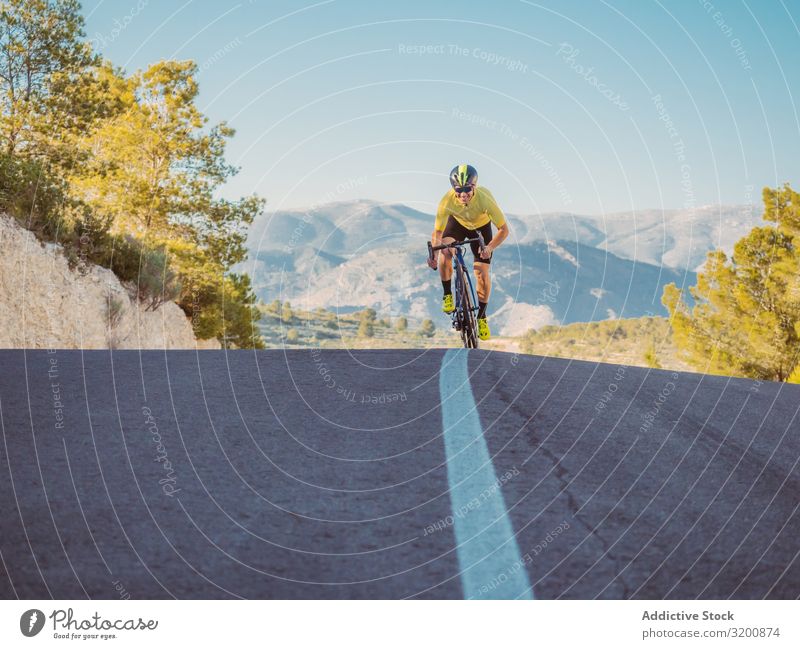 gesunder Mann, der an einem sonnigen Tag auf einer Bergstraße Fahrrad fährt Freizeit & Hobby Athlet Sport Ausritt Rennsport Motorradfahren Außenaufnahme