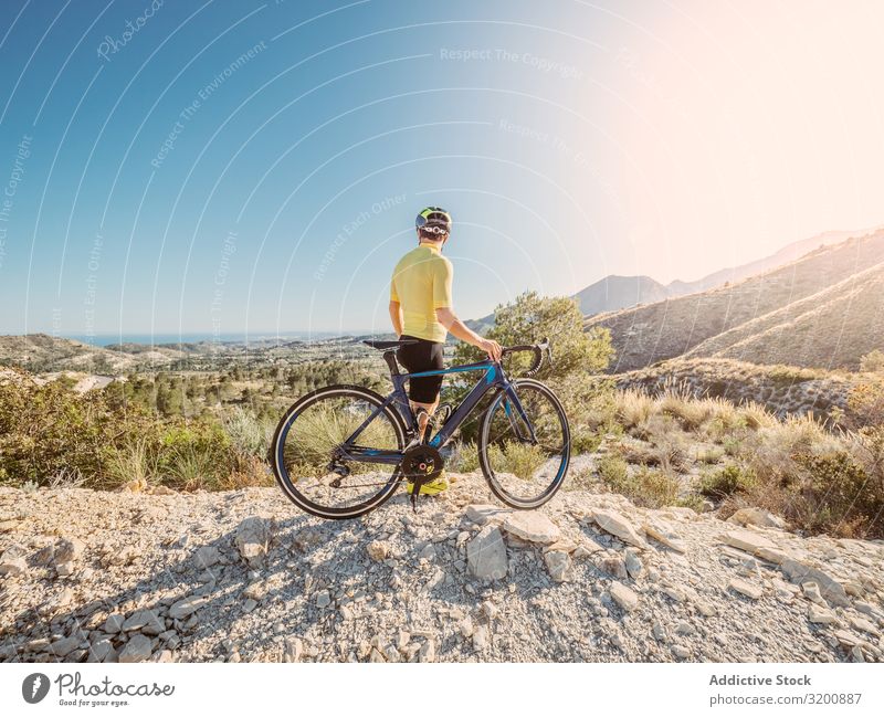 Mann, der sich ausruht und die Aussicht genießt, während er mit dem Fahrrad auf einer Bergstraße fährt Freizeit & Hobby Athlet Sport Ausritt Rennsport