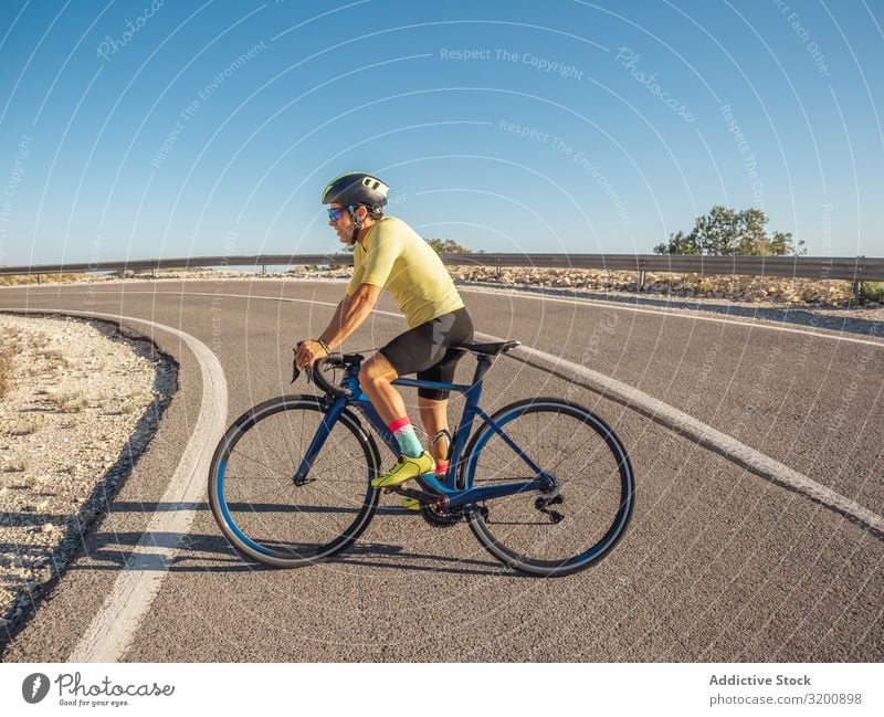 gesunder Mann, der an einem sonnigen Tag auf einer Bergstraße Fahrrad fährt Freizeit & Hobby Athlet Sport Ausritt Rennsport Motorradfahren Außenaufnahme