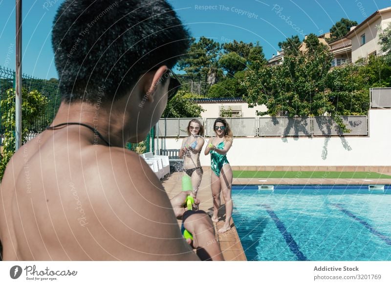 Freunde spielen mit Wasserpistolen im Schwimmbad attraktiv Hintergrundbild schön Bikini Kaukasier heiter Frau Festspiele Freundschaft Freude Mädchen Pistole