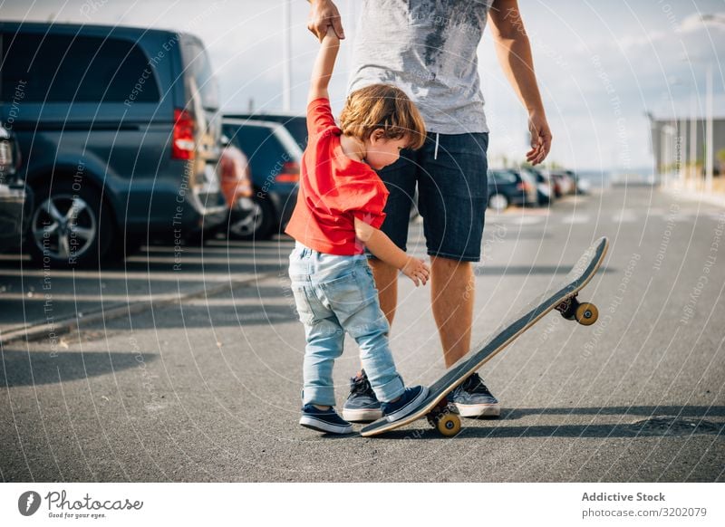 Mann mit Kind trainiert mit dem Skateboard Vater genießend Elternschaft laufen Ferien & Urlaub & Reisen Familie & Verwandtschaft Lehre Zusammensein Freude