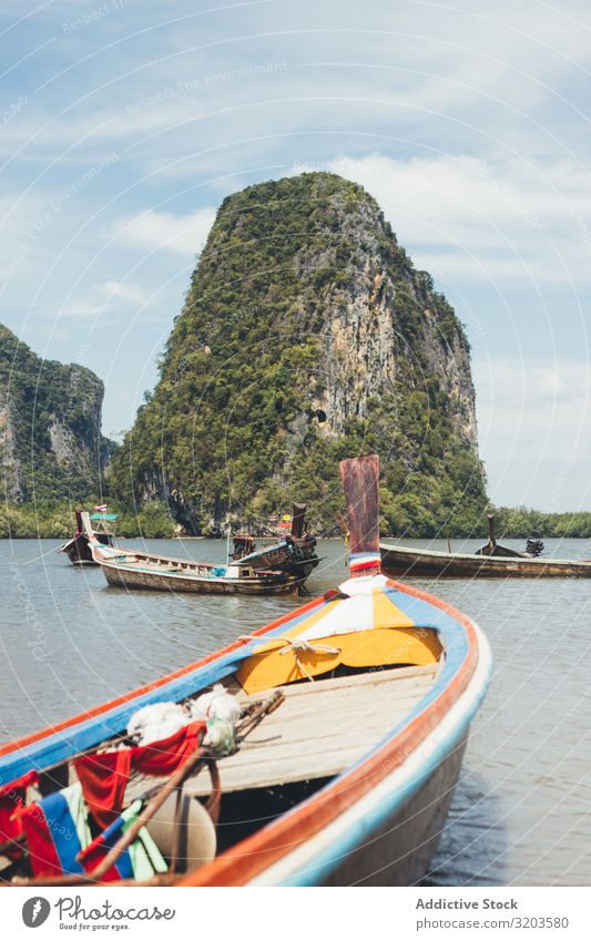 Traditionelle Boote, die in einer tropischen Bucht schwimmen Wasserfahrzeug Lagune Im Wasser treiben Thailand Landschaft grün Felsen Küste Strand