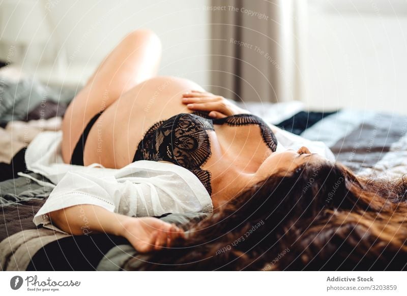 Schwangere Frau in Unterwäsche auf dem Bett liegend schwanger bauchfrei erwartend Baby Fötus Jugendliche Mensch schön attraktiv Mutter nackt ruhig Erotik lügen