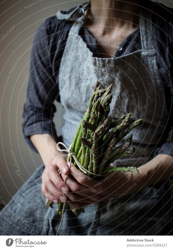 Gesichtslose Frau mit einem Bündel grünen Spargels rustikal Hand Halt organisch Diät Lebensmittel natürlich Ernährung roh Zutaten Vegetarische Ernährung