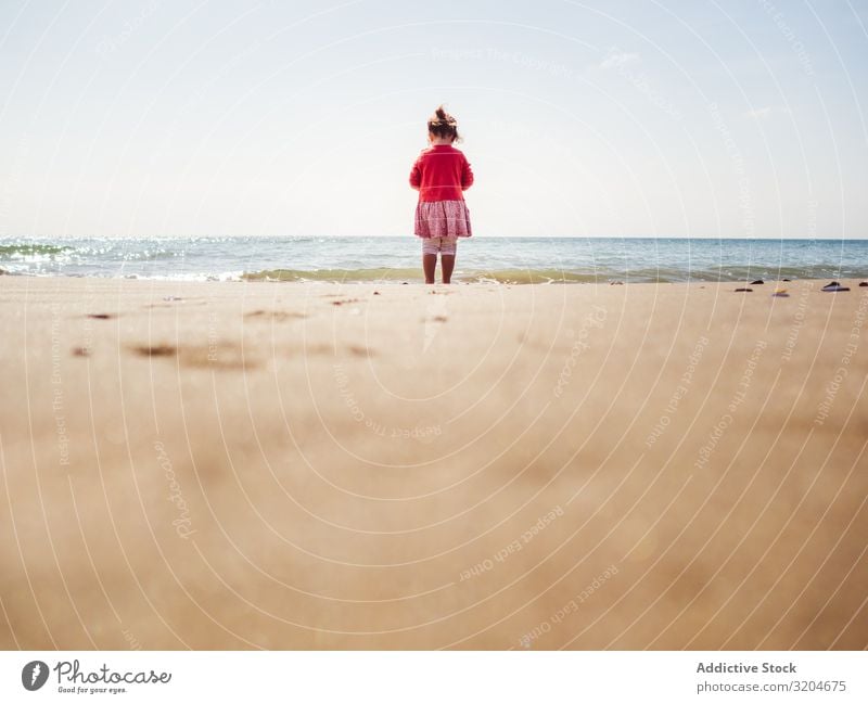 Mädchen, das an einem sonnigen Tag am Strand spazieren geht laufen Sonnenstrahlen Kleinkind Sand Seeküste Wasser ruhig Küste Kindheit Ferien & Urlaub & Reisen