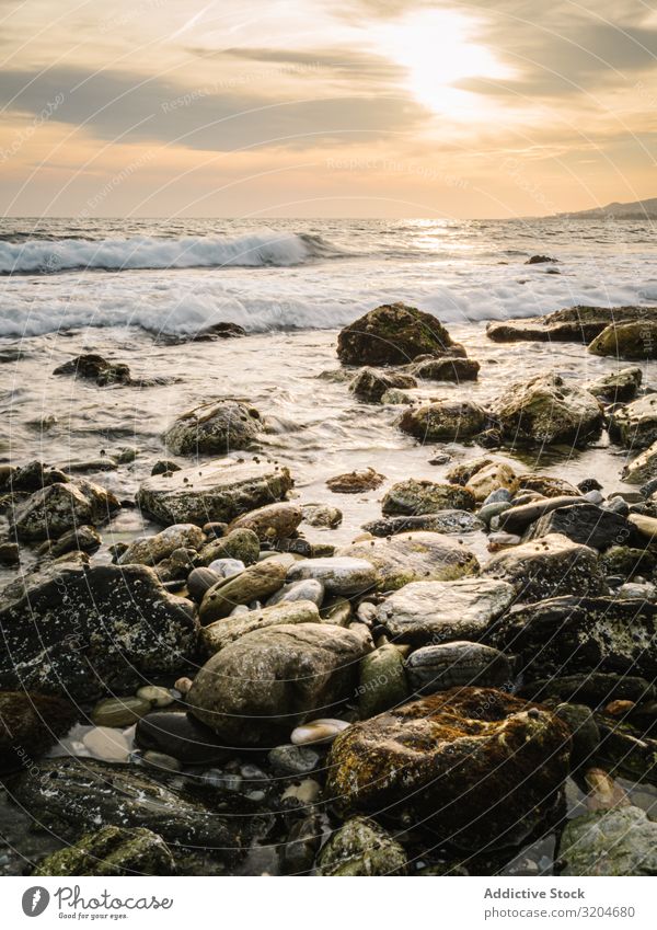 Steinige Küste und Wellen bei schönem Sonnenuntergang steinig winken malerisch nass ruhig Seeküste Himmel Meer Wasser Strand Natur Landschaft Meereslandschaft