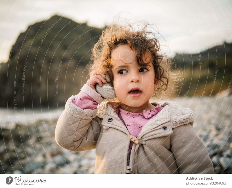 Kleinkind spielt mit Muschel am Strand Mädchen Spielen Kind Aufmerksamkeit entzückt Porträt hören aussruhen Natur Interesse Fundstück verblüfft Freizeit & Hobby