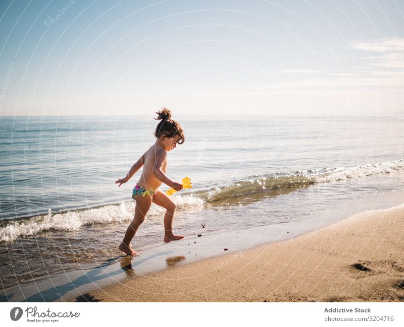 Kleinkind, das am Sandstrand spazieren geht Mädchen Strand laufen Spielen Kind Schwimmsport Meer ruhig Kindheit Sommer Ferien & Urlaub & Reisen Sonnenstrahlen