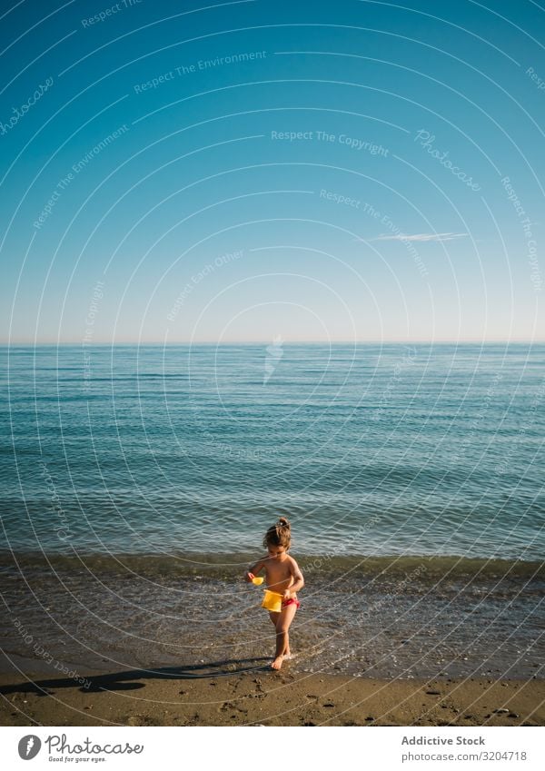 Mädchen spielt mit kleinen Steinen am Strand Spielen Kleinkind Sand Küste ruhig Meer Sonnenstrahlen Seeküste Wasser Kindheit Ferien & Urlaub & Reisen Aktion