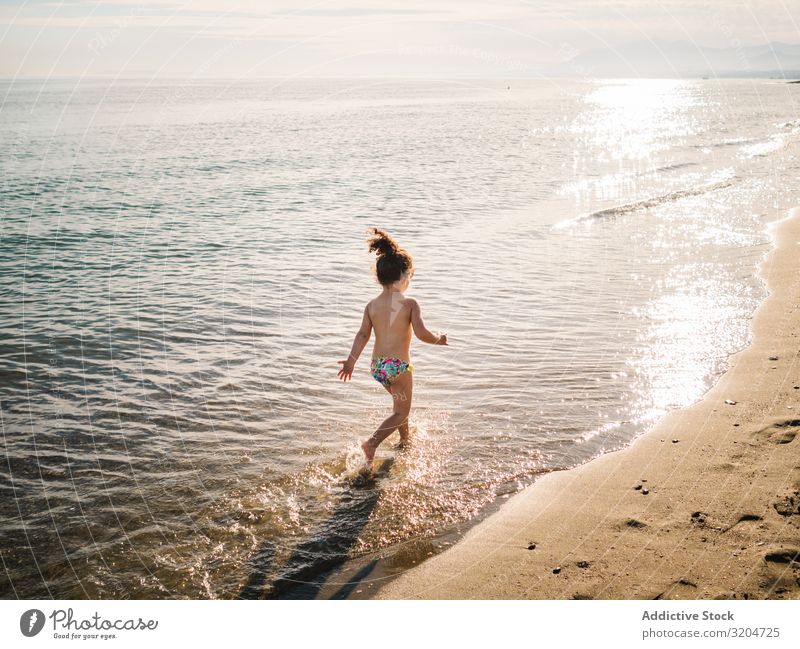 Anonymes Mädchen läuft am Meer rennen Strand Schwimmen & Baden platschen Kind Schwimmsport Sand ruhig Spielen Kindheit genießend Aktion Sommer Kleinkind