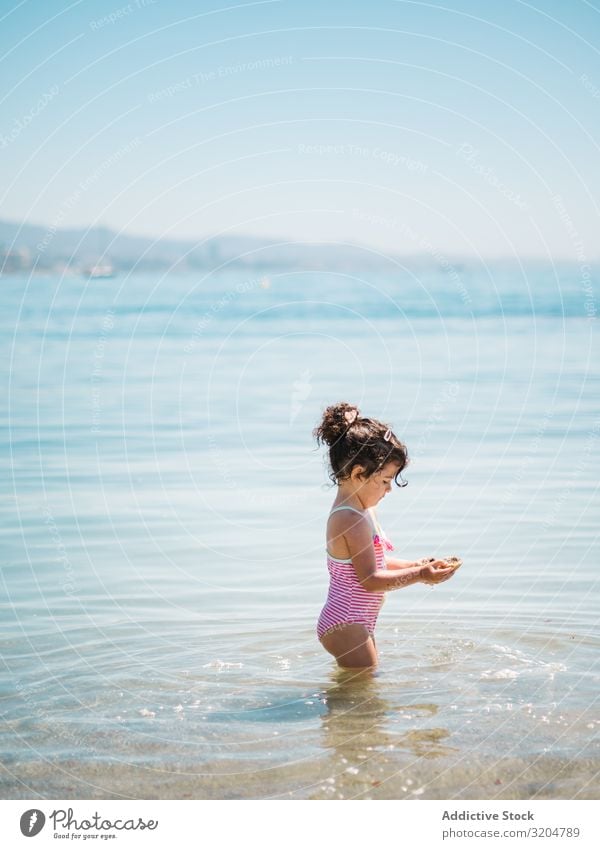 Süßes Mädchen spielt im Wasser der Küste Spielen Seeküste niedlich Kleinkind reizvoll Meer Badeanzug Wärme Strand Sonnenstrahlen Kindheit Schwimmen & Baden