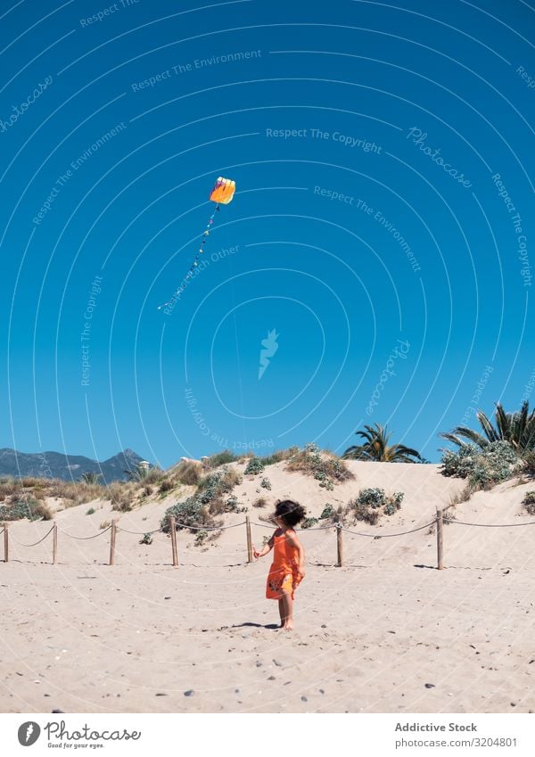 Kleinkind spielt mit Drachen am Sandstrand Mädchen Lenkdrachen Strand Spielen klein Kind Frau fliegen Blauer Himmel rennen Seeküste Ferien & Urlaub & Reisen