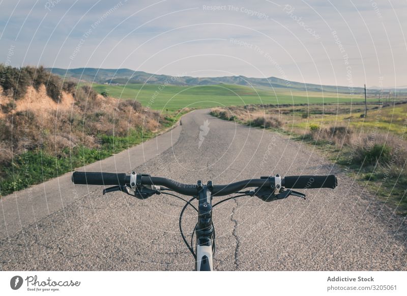 Fahrrad auf der Straße in den Wüstenhügeln ausleeren Hügel Landschaft Sand Stein Pflanze Ausflug regenarm Natur Himmel Ferien & Urlaub & Reisen heiß