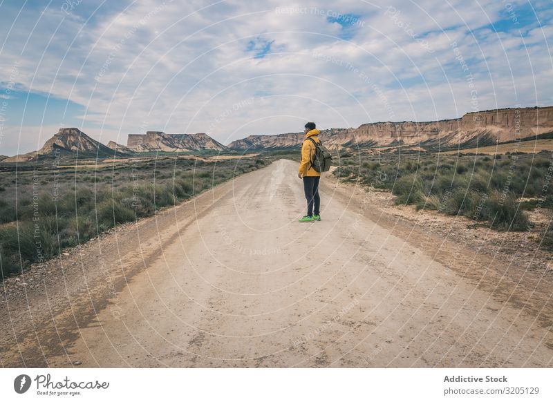 Mann steht auf der Straße in den Wüstenhügeln Hügel Landschaft Sand Stein Pflanze Ausflug regenarm Natur Himmel Ferien & Urlaub & Reisen heiß Ausflugsziel