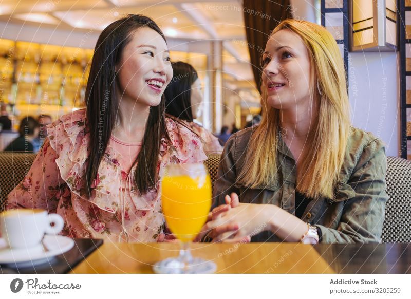 Multiethnische Freunde unterhalten sich im Café Freundschaft Sprechen Zusammensein Frau Jugendliche Person gemischter Abstammung Lächeln sitzen Tisch Lifestyle
