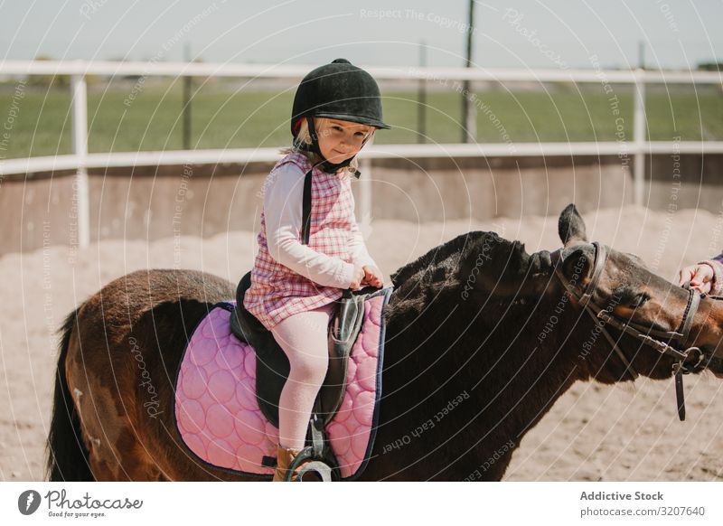 Kleines Mädchen reitet Pferd auf dem Hippodrom Sport Mitfahrgelegenheit Rennbahn Reiterin Kind üben Kindheit lernen bezaubernd wenig Jockey ländlich Glück Tier