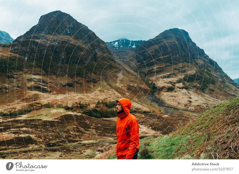 Mann steht vor malerischer Landschaft Berge u. Gebirge Wind Kapuzenpulli Schottland regnet Mantel Natur kalt reisen Ansicht Tal Schönheit Freiheit männlich