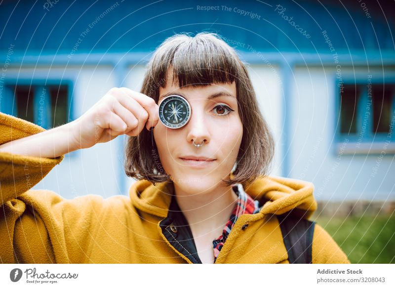 Komische Frau mit Kompass in Augennähe gekreuzte Augen lustig Grimasse Schifffahrt retro Lächeln Abenteuer Tourismus Anleitung Haus altehrwürdig Werkzeug