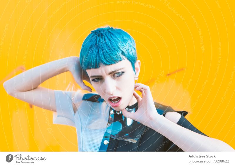 Alternatives Modell-Portrait gegen gelbe Wand Frau futuristisch alternativ Kleid blaue Haare informell Straßenbelag Glamour Dame jung Ausdruck Schönheit Gebäude
