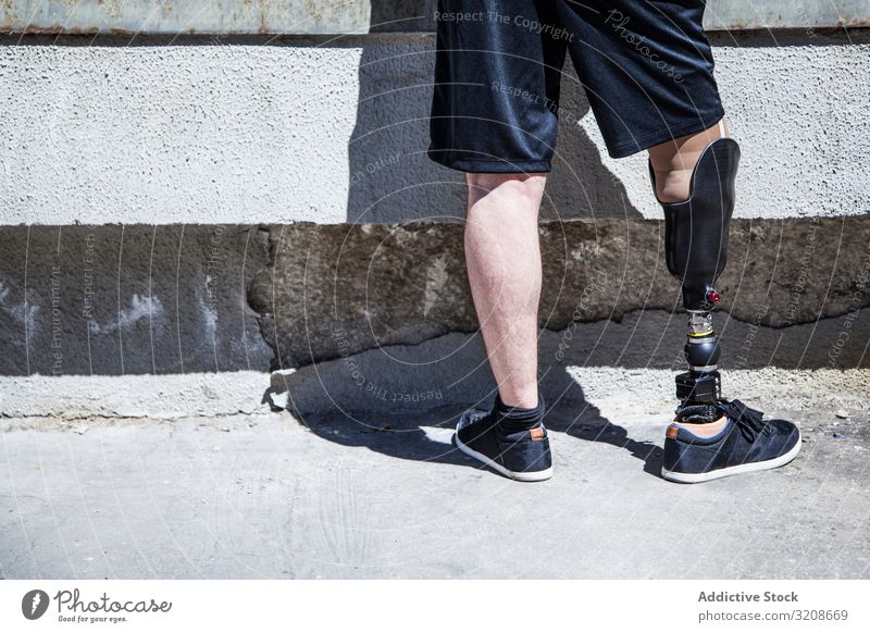 Nicht erkennbarer junger Mann, der mit seiner Beinprothese amputiert wurde Ausdruck deaktivieren männlich Behinderte sitzen Prothesen junger Erwachsener