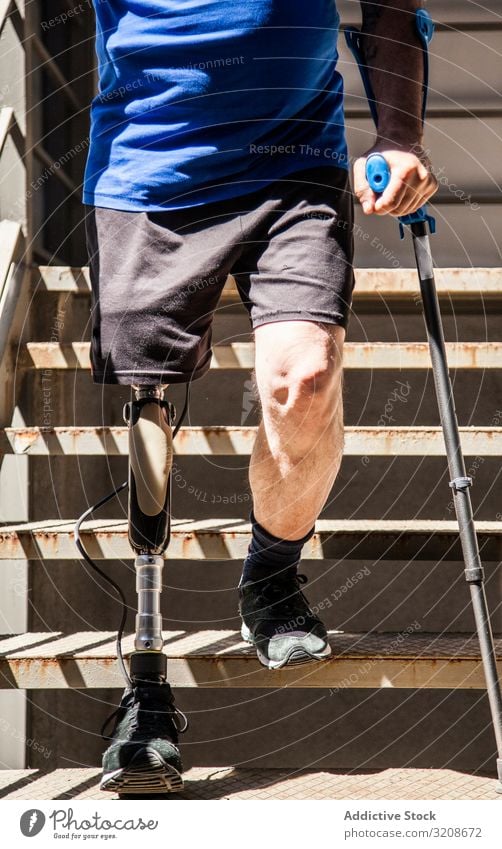 nicht erkennbarer, mit Krücken amputierter Mann, der seine neue Beinprothese testet Ausdruck deaktivieren männlich Behinderte sitzen Prothesen