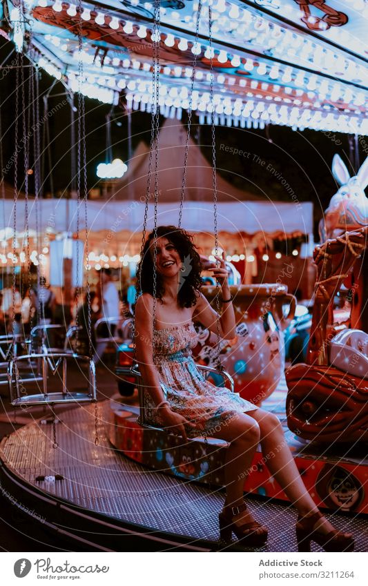 Frau genießt die Fahrt auf dem Karussell Vergnügungspark Mitfahrgelegenheit Sommer heiter Abend Spaß Freizeit brünett genießen Glück jung schön Feiertag Kleid