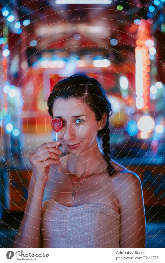 Frau mit Lolli im Vergnügungspark Jahrmarkt Lollipop sich[Akk] entspannen Sommer heiter Spaß Lächeln Freizeit Abend dunkel genießen Glück lässig jung schön