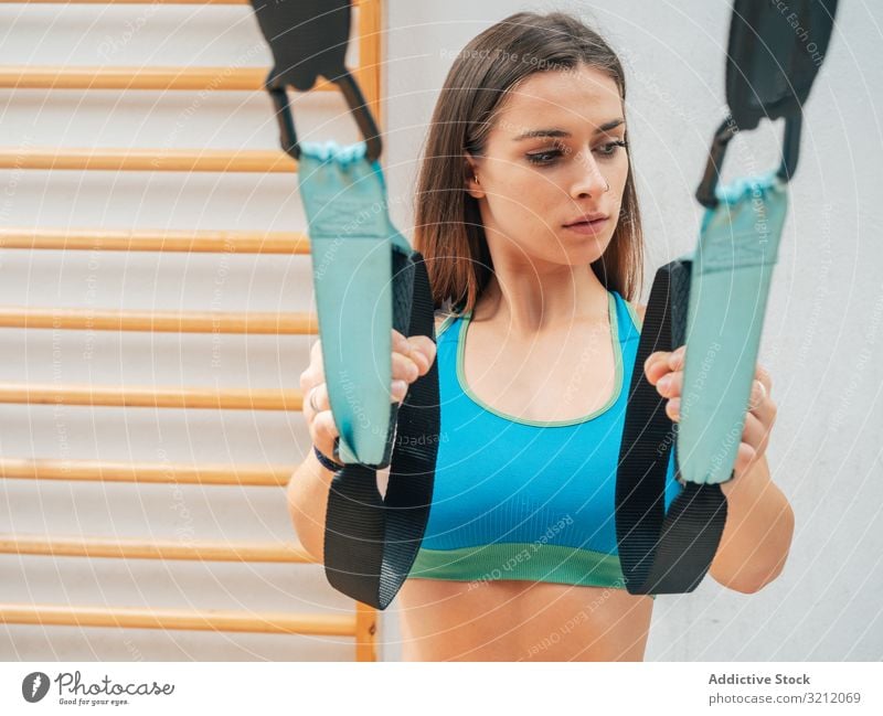 Training junger Frauen in der Turnhalle Sportlerin Suspension Seil Übung trx Körpergewicht erhängen physisch Athlet Fitnessstudio Motivation Stärke Kraft modern