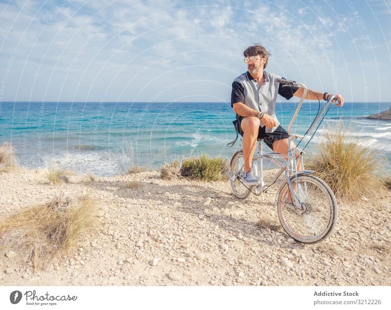 Mann radelt auf Sandstrandhügel Fahrrad sandig Seeküste Urlaub Glück Fahrradfahren Sommer winken aktiv Lifestyle Feiertag Ausflug energetisch reisen Reise