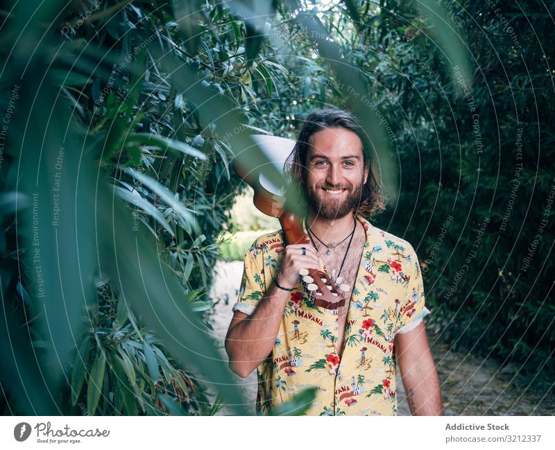 Hipster-Mann im Dschungel mit Ukulele Musiker reisen Abenteuer Ausflug Sommer Lifestyle besinnlich männlich Urlaub Freiheit jung Tourist farbenfroh lässig