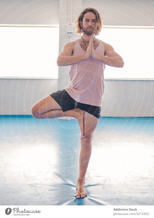Mann macht Yoga in geräumigem Raum Fitnessstudio sich[Akk] entspannen Vitalität Zen Harmonie Übung Asana Sport jung Windstille Frieden männlich bärtig Glück