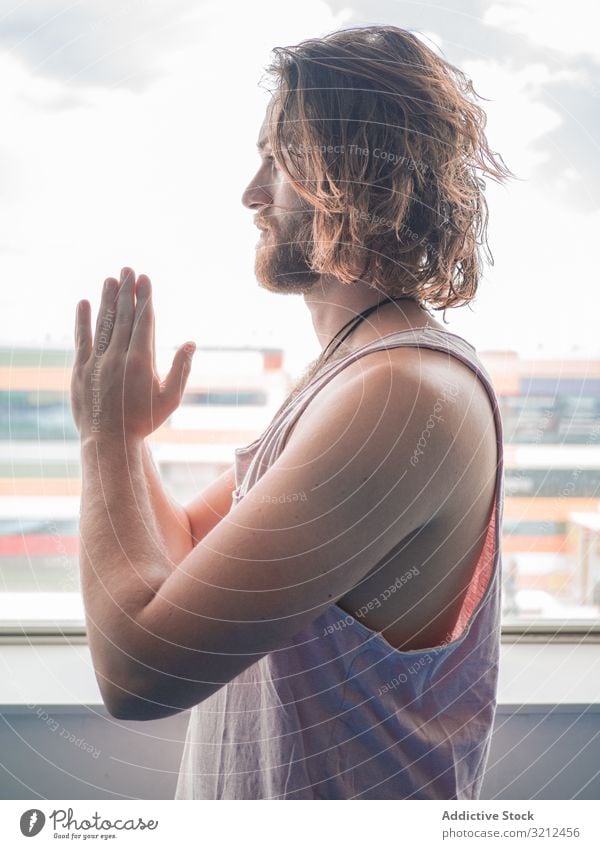 Mann macht Yoga in geräumigem Raum Fitnessstudio sich[Akk] entspannen Vitalität Zen Harmonie Übung Asana Sport jung Windstille Frieden männlich bärtig Glück