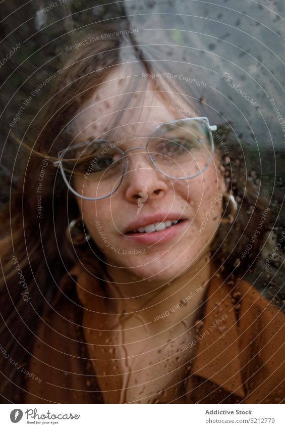 Frau schaut bei Regen aus dem Fenster durch das Fenster Brille allein sich[Akk] entspannen Tag attraktiv nass Erwachsener jung Lifestyle einsam Windstille